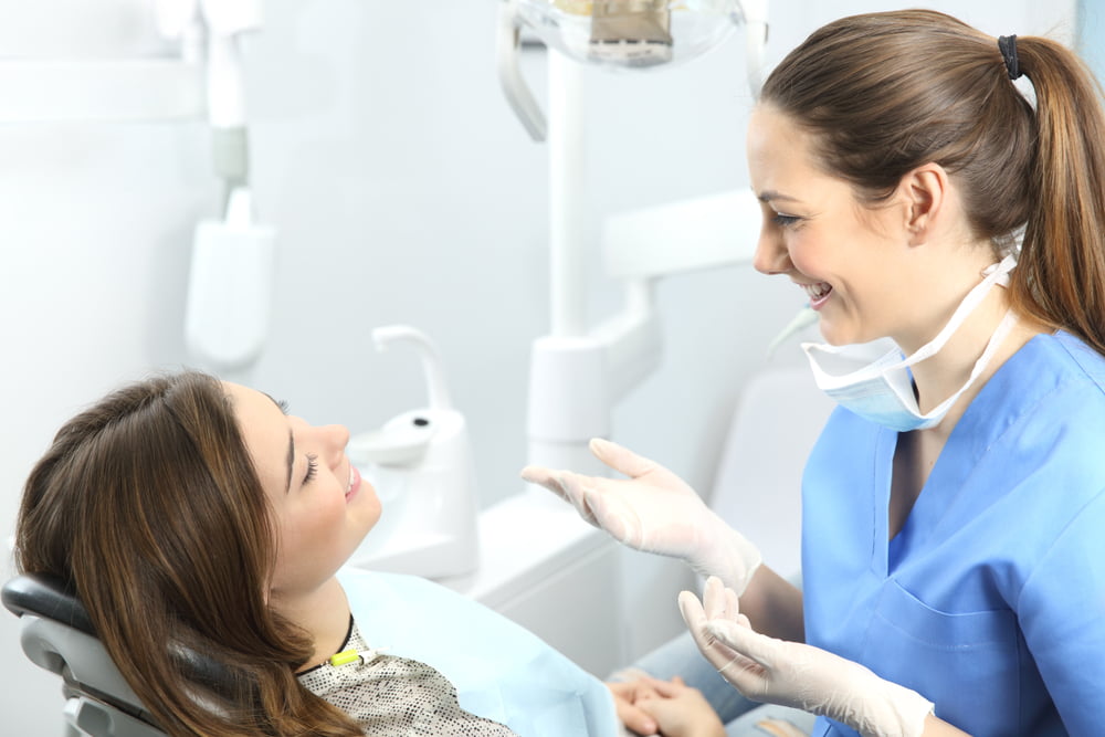 Dentist explaining procedures to a patient in a consultation - Holistic Dentistry